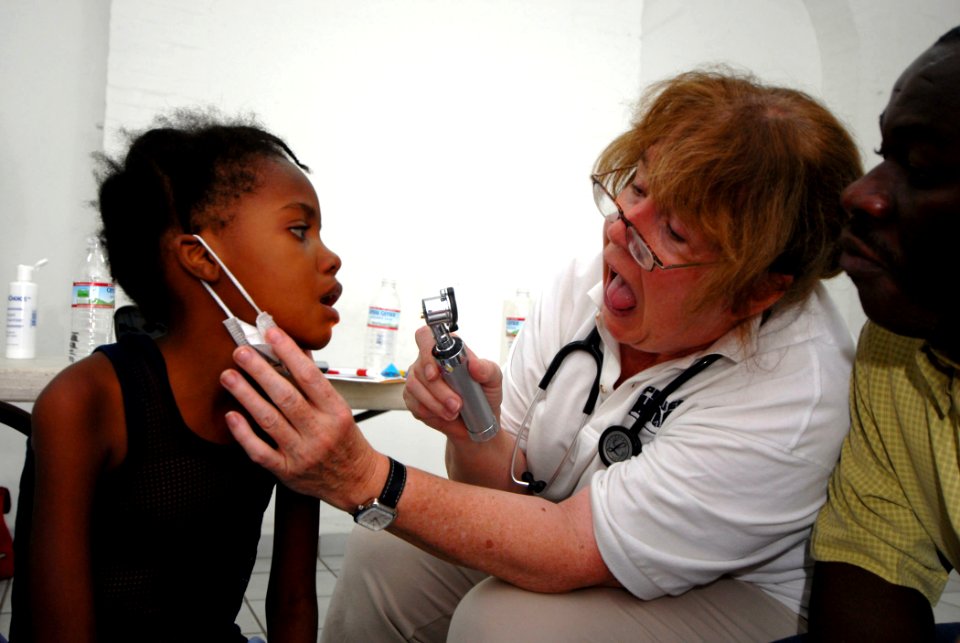 US Navy 070902-N-8704K-139 Carole Ferguson, a Project Hope volunteer attached to Military Sealift Command hospital ship USNS Comfort (T-AH 20), provides medical care for Sofia Etinne at Hopital De L'universite D'etat D'Haiti