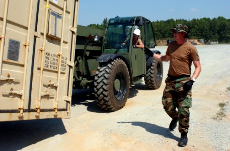 US Navy 070904-N-9936B-011 Interior Communications Electrician 2nd Class Bjorn Anderson, right, and Equipment Operator 2nd Class David Harwell, of Mobile Inshore Undersea Warfare Unit 401, move equipment containers during Exerc