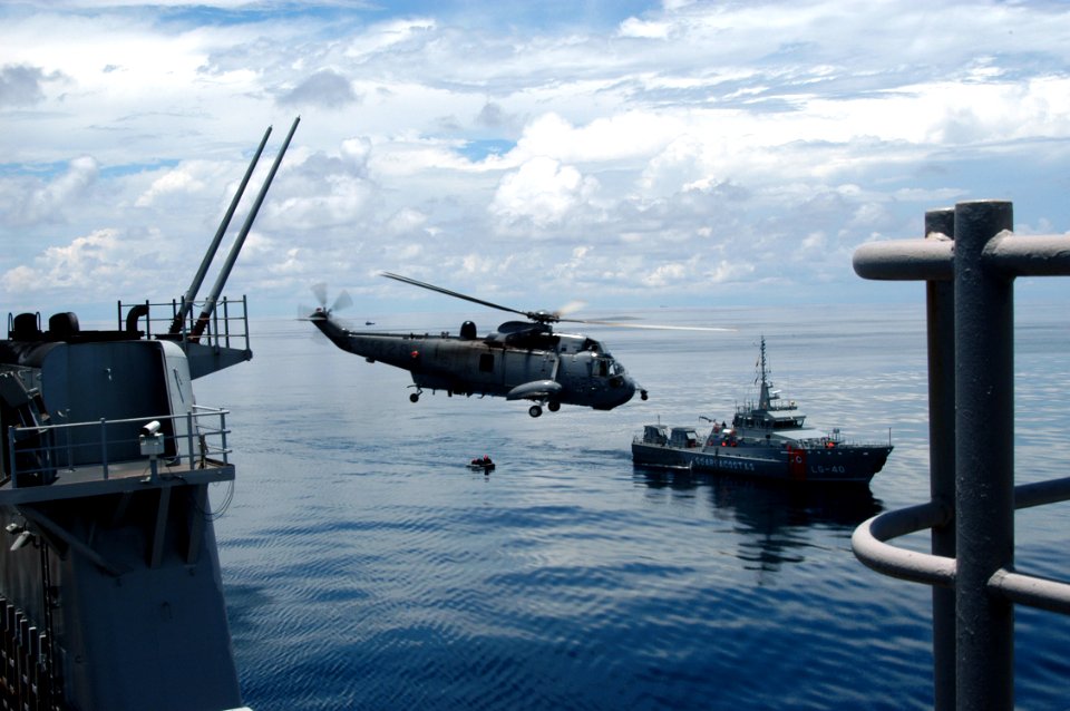 US Navy 070902-N-7029R-014 A Canadian CH-124 Sea King takes off from dock landing ship USS Pearl Harbor (LSD 52) while a rigid hull inflatable boat prepares to embark Ecuadorian surface combat ship LAE 11 De Noviembre (LG 40)