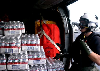 US Navy 070907-N-1189B-031 An aircrew Sailor on board multi-purpose amphibious assault ship USS Wasp (LHD 1), loads bottled water onto an MH-60S Seahawk assigned to Helicopter Sea Combat Squadron (HSC) 28