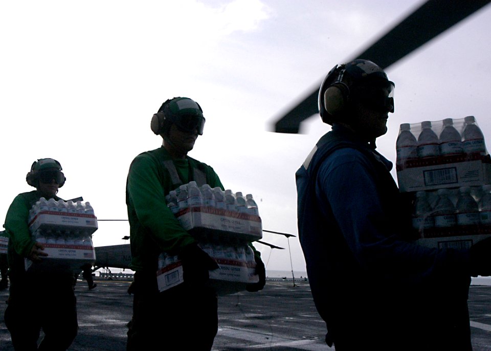 US Navy 070907-N-1189B-022 Sailors on board multi-purpose amphibious assault ship USS Wasp (LHD 1), load bottled water onto an MH-60S Seahawk assigned to Helicopter Sea Combat Squadron (HSC) 28