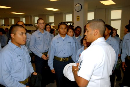US Navy 070905-N-6724S-012 Culinary Specialist 2nd Class Wilson Santiago answers a recruit's question during a visit by a group of Sailors attached to the Precommissioning Unit (PCU) George H.W. Bush (CVN 77)