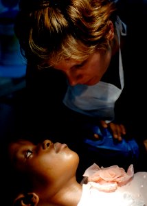 US Navy 070904-N-6278K-214 Canadian Forces Cpl. Julie Belisle, a dental technician attached to the Military Sealift Command hospital ship USNS Comfort (T-AH 20), calms a patient before a tooth extraction at Hôpital