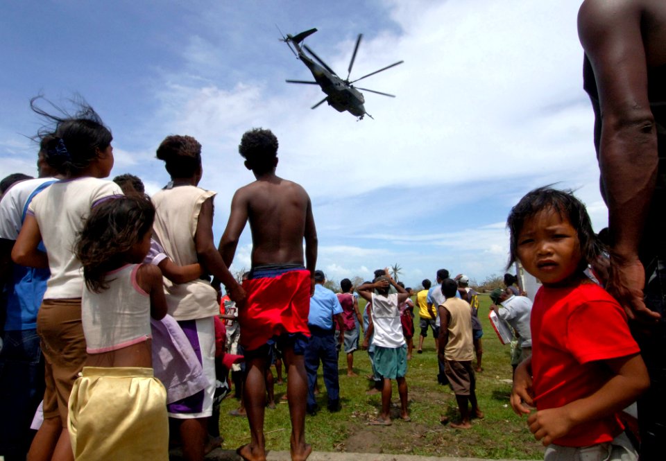 US Navy 070907-N-1810F-031 Local residents look on, as an MH-53 helicopter from amphibious assault ship USS Wasp (LHD 1), participating in Hurricane Relief disaster relief operations