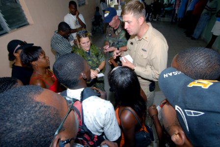 US Navy 070905-N-8704K-022 Chief Hospital Corpsman Joseph Colon, attached to Military Sealift Command hospital ship USNS Comfort (T-AH 20), speaks with local Creole translators before starting medical operations at Hôpital Univ