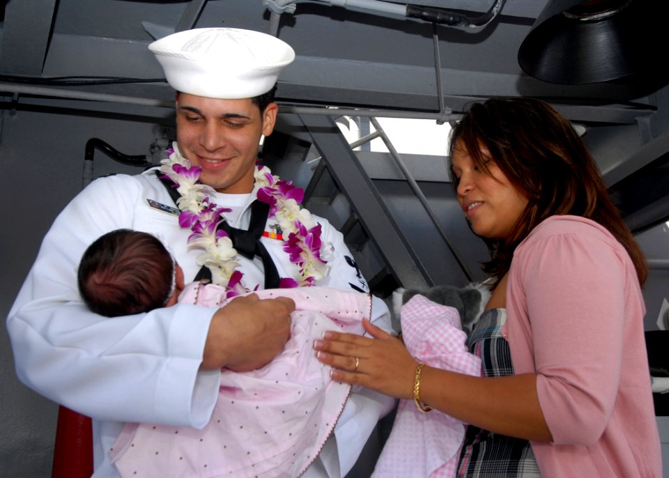 US Navy 070904-N-9758L-217 A Sailor from Ticonderoga-class guided-missile cruiser USS Lake Erie (CG 70) holds his child during a homecoming ceremony marking the ship's completion of a four-month deployment to the Western