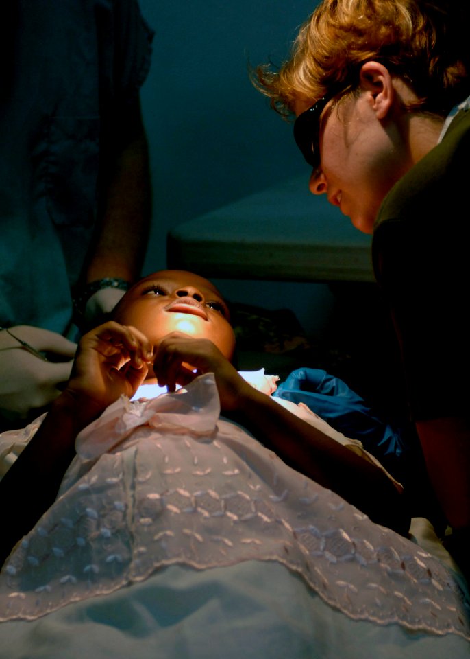 US Navy 070904-N-6278K-161 Canadian Forces Cpl. Julie Belisle, a dental technician attached to Military Sealift Command (MSC) hospital ship USNS Comfort (T-AH 20), calms a patient before a tooth extraction at Hôpital