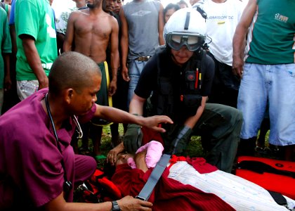 US Navy 070907-N-7540C-002 A Navy search and rescue swimmer prepares an injured woman for a medical evacuation photo