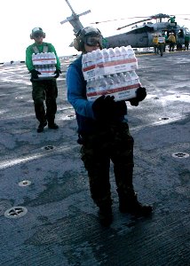 US Navy 070907-N-1189B-021 Sailors on board multi-purpose amphibious assault ship USS Wasp (LHD 1), load bottled water onto an MH-60S Seahawk assigned to Helicopter Sea Combat Squadron (HSC) 28