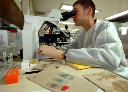 US Navy 070905-N-0194K-029 Lt. Paul Graf, a microbiology officer aboard Military Sealift Command hospital ship USNS Comfort (T-AH 20), examines wound cultures in the ship's microbiology laboratory