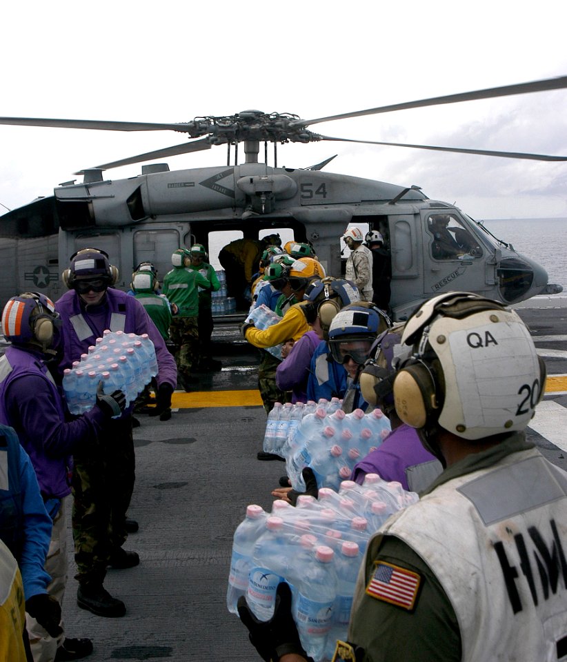 US Navy 070907-N-1189B-125 crew members load bottled water onto an MH-60S Seahawk helicopter during Hurricane Felix disaster relief operations
