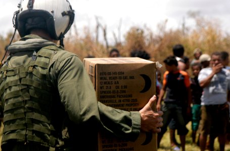 US Navy 070907-N-1189B-033 A U.S. Navy aircrewman attached to the multi-purpose amphibious assault ship USS WASP (LHD 1) carries a box of Meals Ready to Eat (MRE) to the citizens of Puerto Cabezas, Nicaragua photo