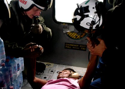 US Navy 070907-N-1189B-206 U.S. Navy aircrewmen comfort an injured Nicaraguan woman prior to take-off during a medical evacuation photo