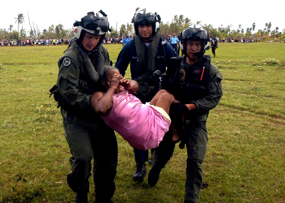 US Navy 070907-N-1189B-219 U.S. Navy aircrewmen attached to USS Wasp (LHD 1) carry an injured woman to a helicopter for medical evacuation during disaster relief efforts