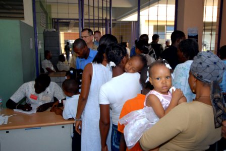 US Navy 070905-N-8704K-034 Creole translator Simillen Lucson, left, helps check patients in to Hôpital Universitaire de la Paix, where Military Sealift Command hospital ship USNS Comfort (T-AH 20) personnel are providing medica
