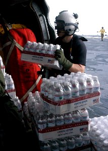 US Navy 070907-N-1189B-028 An aircrew Sailor on board multi-purpose amphibious assault ship USS Wasp (LHD 1), loads bottled water onto an MH-60S Seahawk assigned to Helicopter Sea Combat Squadron (HSC) 28