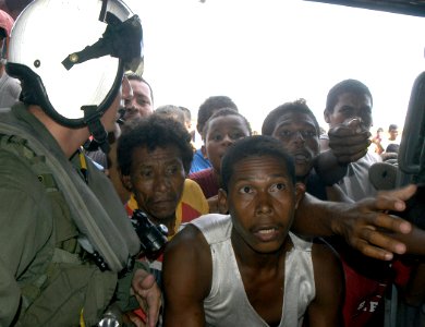 US Navy 070907-N-1189B-034 Citizens from Puerto Cabezas receive bottled water from an MH-60S helicopter attached to the multi-purpose amphibious assault ship USS Wasp (LHD 1) photo