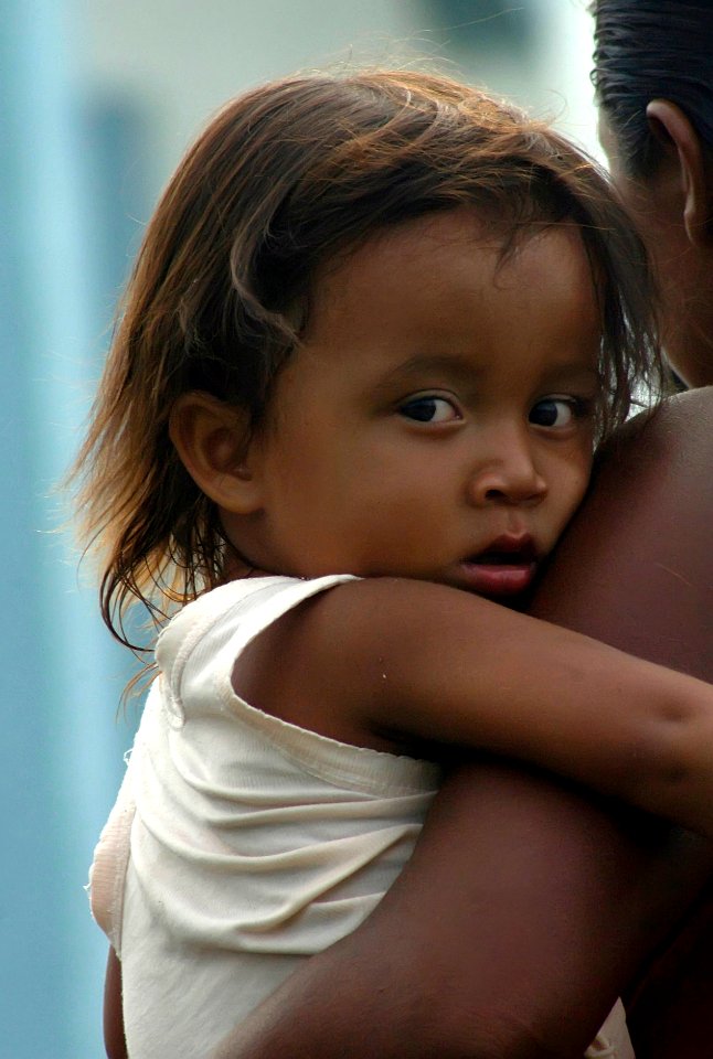 US Navy 070907-N-1810F-058 A Nicaraguan child and her mother in an area affected by Hurricane Felix await the delivery of disaster relief supplies photo