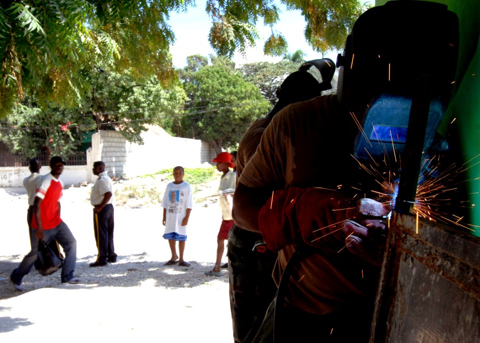 US Navy 070906-N-6278K-223 Steelworker 3rd Class Joel Washington, a Seabee assigned to Construction Battalion Maintenance Unit (CBMU) 202, welds a gate for a local health training center