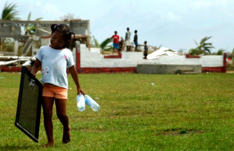 US Navy 070907-N-1810F-056 A young girl in an area affected by Hurricane Felix carries water bottles delivered by helicopters from the amphibious assault ship USS Wasp (LHD 1)