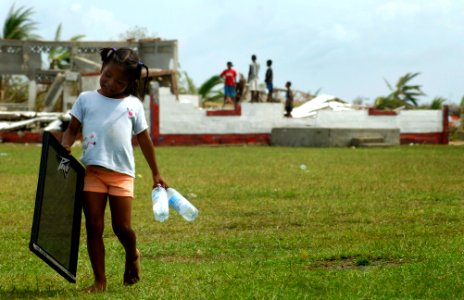 US Navy 070907-N-1810F-056 A young girl in an area affected by Hurricane Felix carries water bottles delivered by helicopters from the amphibious assault ship USS Wasp (LHD 1) photo