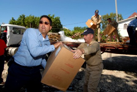 US Navy 070907-N-8704K-095 Hospital Corpsman 1st Class Aaron Sill and Lt. Cmdr. Karl Kish, a Navy chaplain, both attached to the Military Sealift Command hospital ship USNS Comfort (T-AH 20), offload donated medical equipment f photo