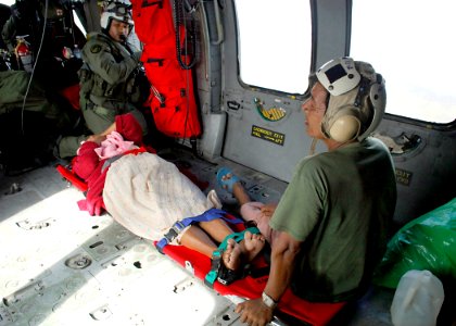 US Navy 070907-N-7540C-007 An aircrewman checks on an injured passenger just before take-off during a medical evacuation