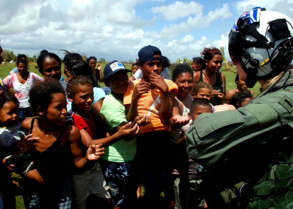 US Navy 070907-N-7540C-029 PUERTO CABEZAS, Nicaragua (Sept. 7, 2007) - A U.S. Navy pilot hands out candy to local children while delivering food and water