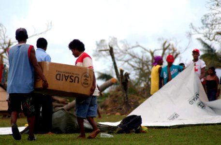 US Navy 070907-N-1810F-063 Nicaraguan citizens carry boxes of Meals Ready-to-Eat (MREs) to their homes after the food was delivered by Sailors attached to multi-purpose amphibious assault ship USS Wasp (LHD 1) photo