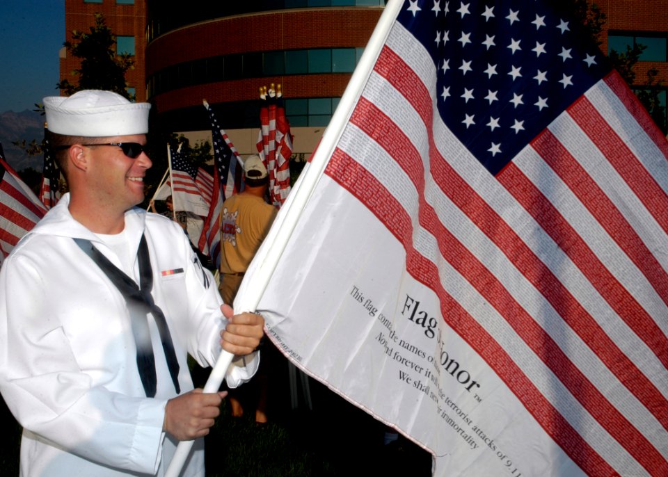 US Navy 070909-N-5208T-002 Hospital Corpsman Seaman Apprentice Brett Olsen prepares Freedom Flags for a two-mile Freedom Walk in support of troops fighting the global war on terrorism