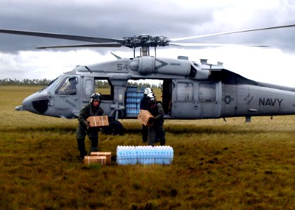 US Navy 070907-N-1189B-201 U.S. Navy aircrewmen attached to the multi-purpose amphibious assault ship USS Wasp (LHD 1) unload food and water from a MH-60S Seahawk helicopter photo