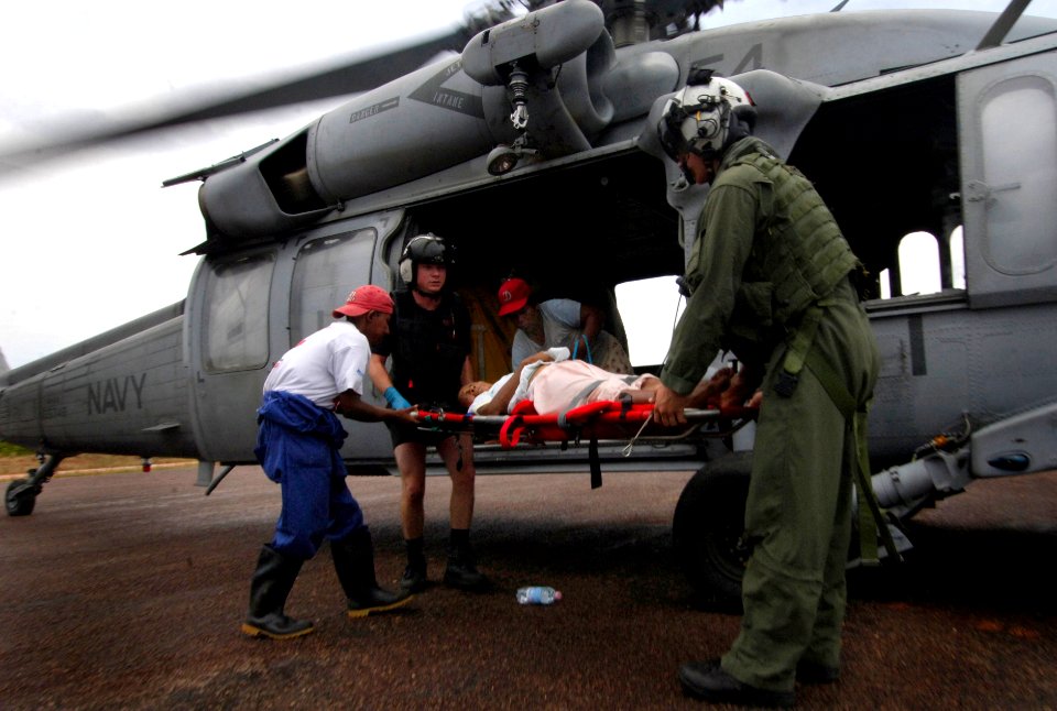 US Navy 070907-N-1810F-019 MH-60S helicopter crew members from amphibious assault ship USS Wasp (LHD 1) prepare to transport a woman, injured during Hurricane Felix