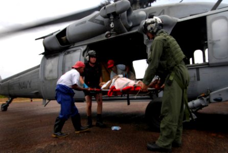 US Navy 070907-N-1810F-019 MH-60S helicopter crew members from amphibious assault ship USS Wasp (LHD 1) prepare to transport a woman, injured during Hurricane Felix photo