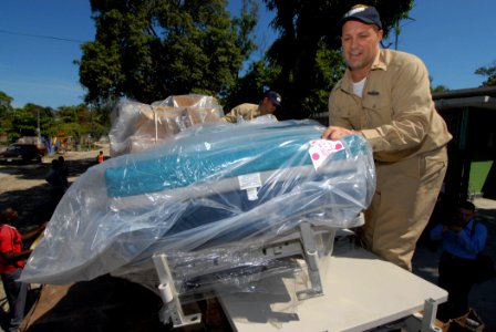 US Navy 070907-N-8704K-065 Senior Chief Operations Specialist Eugene Demers, attached to the Military Sealift Command hospital ship USNS Comfort (T-AH 20), prepares to offload a medical bed donated by Project Handclasp