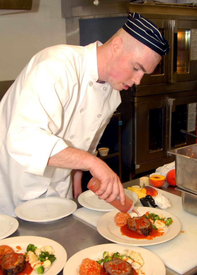 US Navy 070907-N-7656R-002 Culinary Specialist 2nd Class Sean Corcoran, assigned to Naval Station Everett Galley, puts the final touches on meatloaf during a culinary arts competition