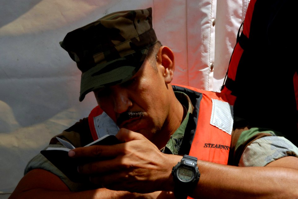 US Navy 070907-N-8704K-157 Equipment Operator 1st Class Manuel Gradillas reads a Bible while transiting via lifeboat to Military Sealift Command hospital ship USNS Comfort (T-AH 20)