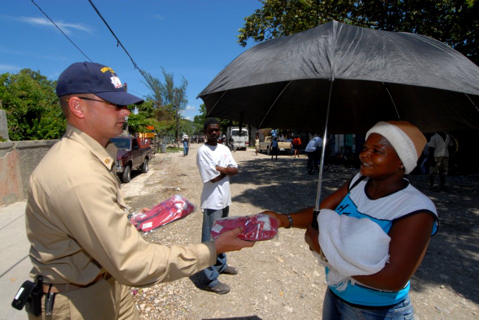 US Navy 070907-N-8704K-134 Senior Chief Sonar Technician Surface Scott Pageau gives a woman a pair of sandals donated by Project Handclasp at Centre de Sante, a health-training center in Croix-des-Bouquet, Haiti