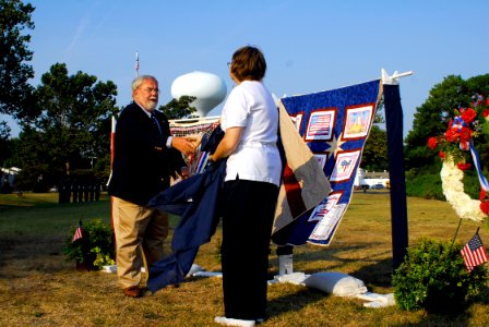 US Navy 070911-N-0193M-127 Hampton mayor Ross A. Kearney II shakes hands with Peggy Mertz, a member of the Remote ^ Waiting Spouses, after reveling a patriotic quilt made for the 6th Annual Day photo