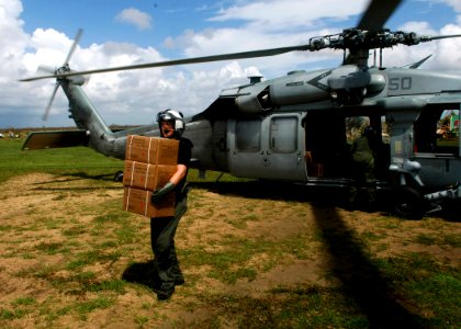 US Navy 070907-N-7540C-063 A U.S. Navy aircrewman carries boxes of food from a U.S. helicopter during disaster relief efforts in Nicaragua