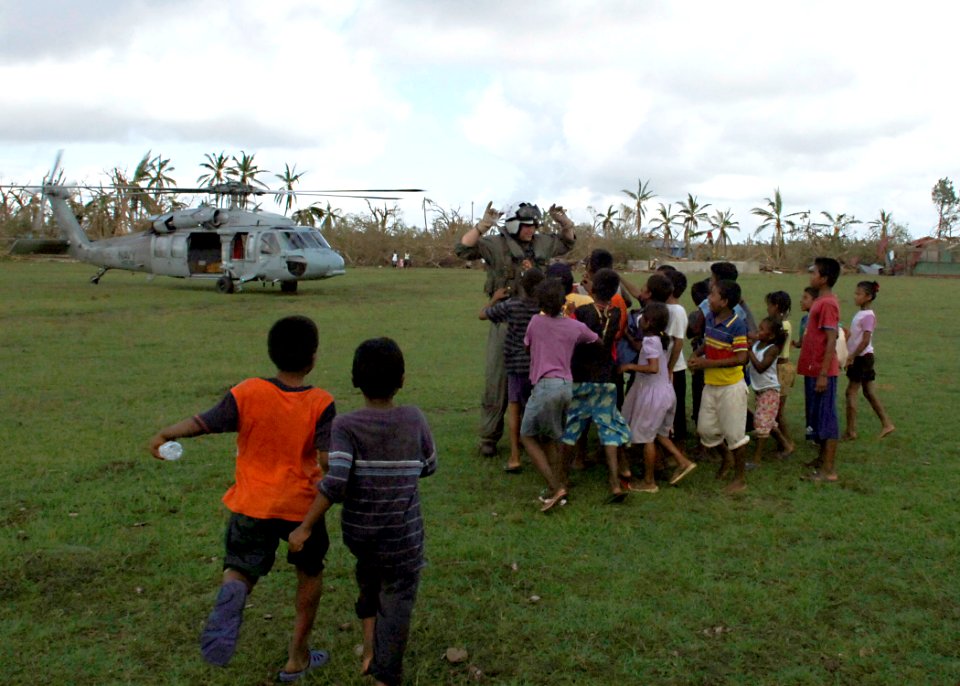 US Navy 070907-N-7540C-003 A Sailor assigned to multi-purpose amphibious assault ship USS Wasp (LHD 1) plays with a group of Nicaraguan children