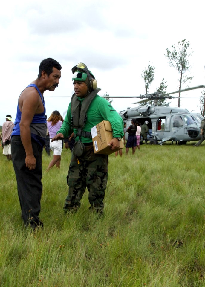 US Navy 070907-N-7540C-041 A Sailor assigned to the multi-purpose amphibious assault ship USS Wasp (LHD 1), talks with a citizen of Puerto Cabezas, Nicaragua, while delivering relief supplies