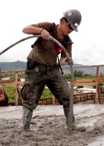 US Navy 070912-F-8678B-080 Builder Constructionman Lauren M. Nikaido, attached to Naval Mobile Construction Battalion (NMCB) 4, uses a concrete vibrator to ensure concrete is even and free of air bubbles during an overhead conc photo