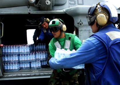 US Navy 070907-N-7540C-042 Sailors from the multi-purpose amphibious assault ship USS WASP (LHD 1), load bottled water and Meals Ready to Eat (MRE) into an MH-60S Seahawk helicopter during disaster relief efforts in Nicaragua photo