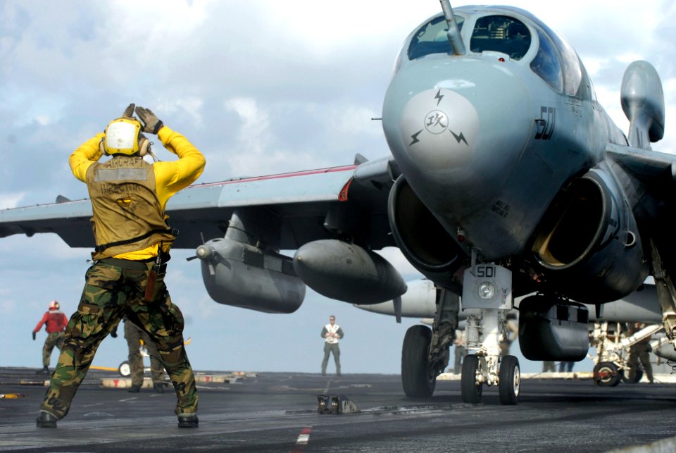 US Navy 070910-N-7883G-012 An aircraft director guides the pilot of an E-A-6B Prowler assigned to the of Electronic Attack Squadron (VAQ) 136 to a catapult aboard USS Kitty Hawk (CV 63)