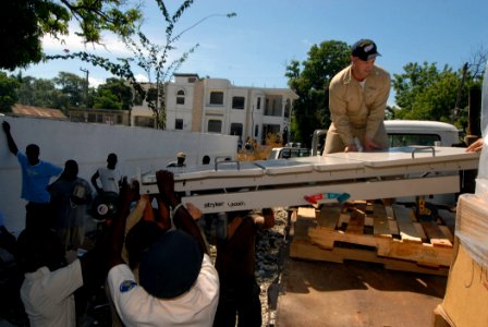 US Navy 070907-N-8704K-077 Senior Chief Operations Specialist Eugene Demers, attached to Military Sealift Command hospital ship USNS Comfort (T-AH 20), joins local policemen in offloading a medical bed donated by Project Handcl