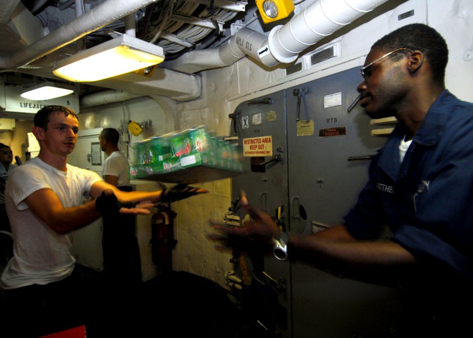 US Navy 070909-N-0841E-376 Sailors aboard guided-missile frigate USS Carr (FFG 52) help store supplies during a vertical replenishment with Military Sealift Command fleet replenishment oiler USNS Tippecanoe (T-AO 199)