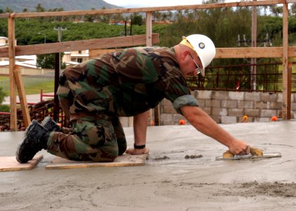 US Navy 070912-F-8678B-105 Chief Utilitiesman James A. Deneen, attached to Naval Mobile Construction Battalion (NMCB) 4, uses a magnesium hand float to finish concrete during an overhead concrete pour at Orote Point quarry