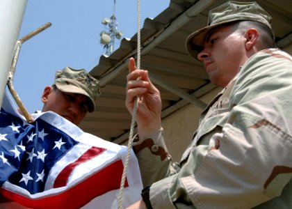 US Navy 070911-N-3285B-157 Storekeeper 1st Class David Trimble and Religious Program Specialist 1st Class Wayne George raise a flag over Camp Lemonier photo