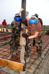 US Navy 070912-F-8678B-042 Steelworker Constructionman Steven A. Amador and Steelworker Constructionman Troy Franklin, attached to Naval Mobile Construction Battalion (NMCB) 4, direct the flow of concrete from the boom of the p