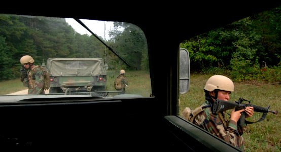 US Navy 070910-N-6639M-053 Master-at-Arms 3rd Class Kristie Sloan, right, provides security beside a humvee, while Chief Master-at-Arms Sven Hunt uses a satellite phone during COMET 2007